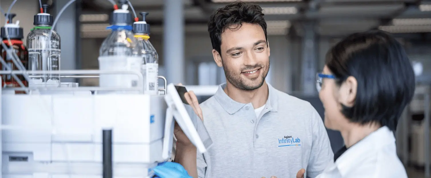 a man smiling at a woman in a laboratory